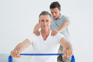 Fototapeta premium Therapist massaging mans shoulder in gym hospital