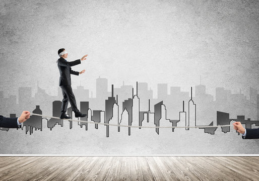 Business concept of risk support and assistance with man balancing on rope