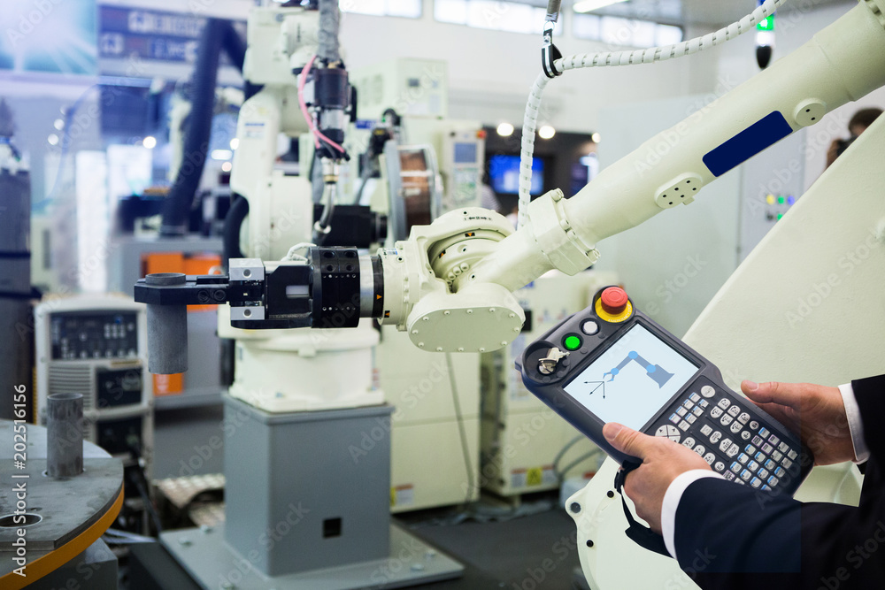 Aufkleber Engineer with teach pendant device. Programming robot with robotic arm. Smart factory 