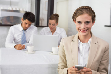 Fototapeta na wymiar Businesswoman text messaging with colleagues at office desk