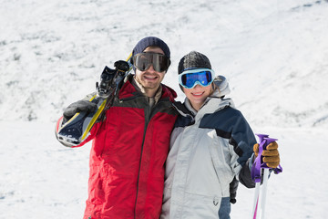 Fototapeta na wymiar Portrait of a happy couple with ski boards on snow