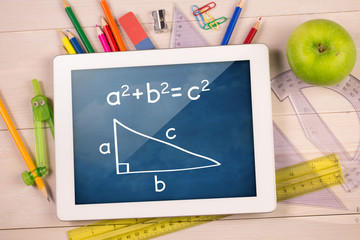 Composite image of digital tablet on students desk showing math equations