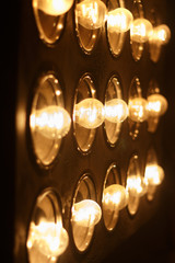 Light bulbs background over dark wall, blur