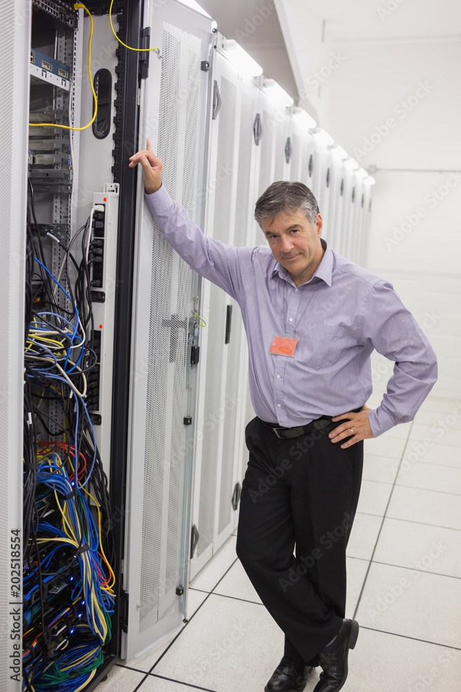 Poster Man standing next to a server tower