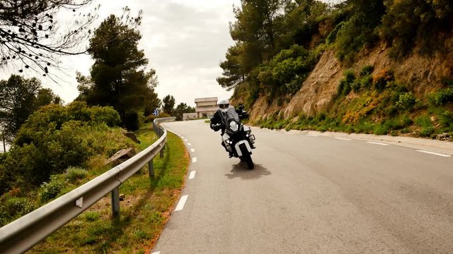 Motorcyclist Driving his Sports Motorbike on a Curvy Road.
Steady cam shot of a young man with his motorbike in spring.
Front view of a cross motorcycle in action on a scenic road in Catalonia.