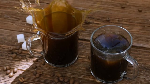 Cinemagraph - Water  whirl in cup of coffee on the wooden table . Motion Photo. 