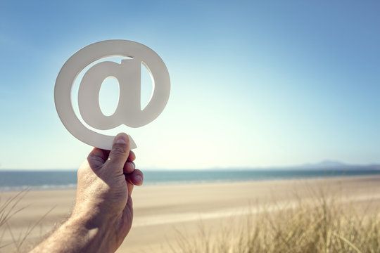 Email at symbol on the beach summer background