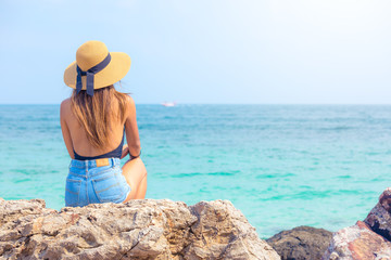 beautiful women with hat looking to the ocean in Thailand , beach vacations