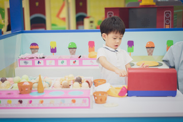 A little chef is playing a ice-cream toy.