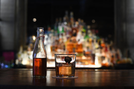 Cocktail and bottle on bar counter