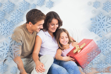 Parents offering a gift against snowflake frame