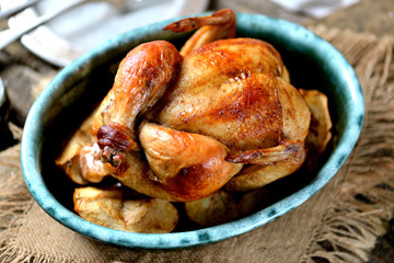 Chicken baked with apples on an old wooden background.