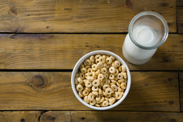 Cereal rings and milk on wooden table