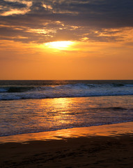 Naklejka na ściany i meble Beach of the ocean and golden sun rise.