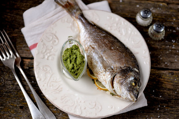 Baked white sea dorado fish with homemade pesto sauce.
