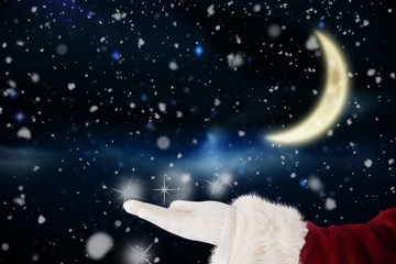 Obraz na płótnie Canvas Santa Claus shows open hand against crescent moon in the night sky