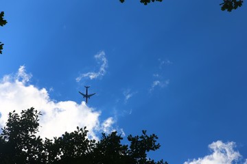 Airplane in the sky - cloudy but sunny day