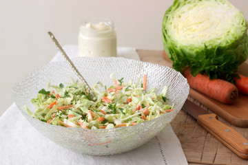 Fresh coleslaw salad in bowl and ingredients for salad. Rustic style.