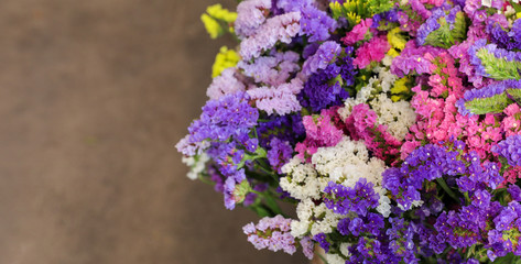Variety of limonium sinuatum or statice salem flowers in blue, lilac, violet, pink, white, yellow colors in the greek garden shop.