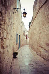 Bardzo wąska i kręta uliczka, między budynkami z wapienia, w starodawnym stylu - Mdina, Valletta