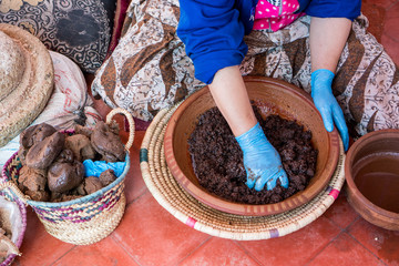 Muslim women making argan oil in traditional way in Morocco. Traditional production of argan oil used for cosmetics and in food preparation