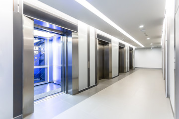 Modern steel elevator doors opened cabins in a business lobby or Hotel, Store, interior, office,perspective wide angle. Four elevators in hotel lobby. - obrazy, fototapety, plakaty