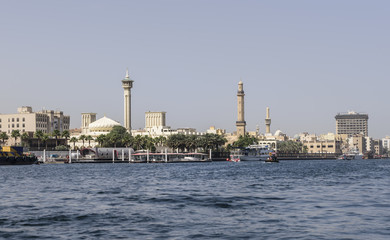 Old Dubai, viewed from the creek, with ancient mosques, along the river bank. The sky is blue and clear
