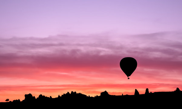 Hot air balloon silhouette in mountains at sunrise, Goreme, Cappadocia, Turkey