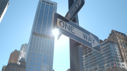 CLOSE UP: One way street signs at intersection on sunny day in New York City