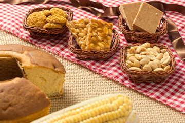 Pacoca, Pe de Moleque, Peanut, Cookie, Cake, Corn: food of Festa Junina, a typical brazilian party. On red and white plaid pattern and jute.