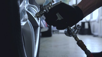 Professional coating of ceramic wheels and rubber, spray gun for painting, car service, shop, washing.