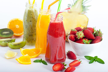 Summer Fruit cocktail smoothie with strawberries, pineapple and kiwi in bottles. White background. 