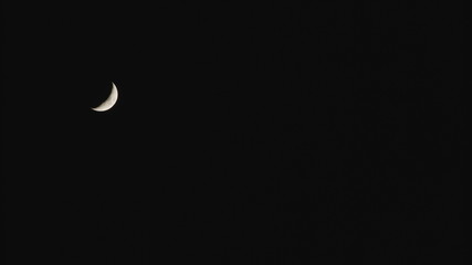 Obraz na płótnie Canvas New moon in the pitchblack sky. Long shot