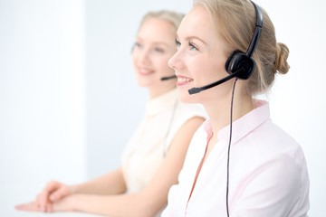 Naklejka premium Image of bright call center. Focus on young beautiful woman in a headset