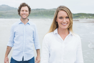 Smiling casual young couple at beach