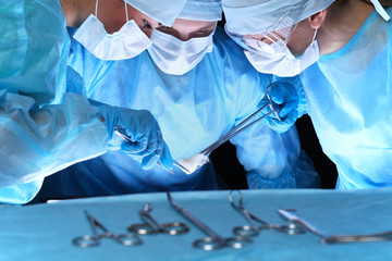 Group of surgeons in masks performing operation. Medicine, surgery and emergency help concepts