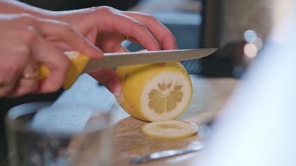 Close-up of clean hands slicing a lime in the kitchen