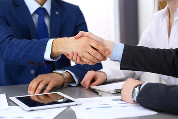 Business people shaking hands, finishing up a papers signing. Meeting, agreement and lawyer consulting concept