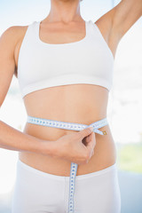 Self confident woman measuring her waist