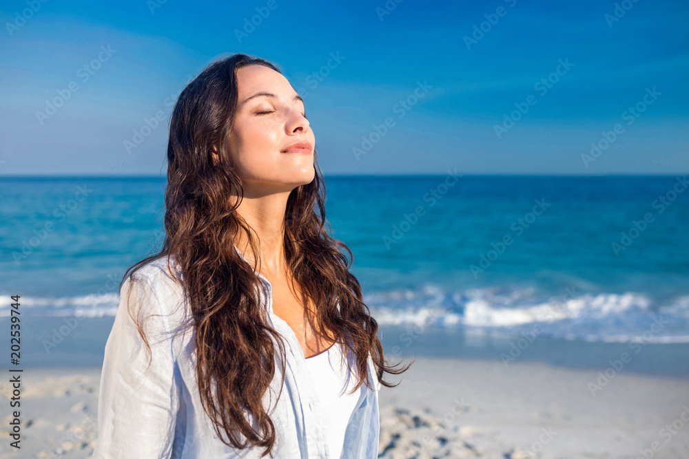 Wall mural Happy woman with eyes closed at the beach