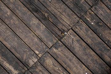 Close up texture background of old dark wooden boards asymmetrically arranged in a floor