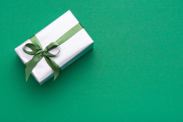 Hands holding wrapped gift box with colored ribbon as a present for Christmas, new year, mother's...