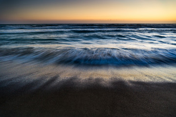 Fototapeta na wymiar Sea waves in motion in sunset