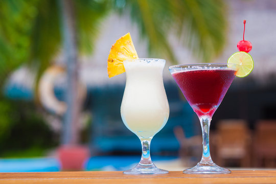 two glasses of fruit cocktail by the beach