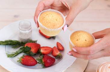 Making cupcakes. Photo of process. Homemade muffins. Ñonfectioner woman decorating cupcakes strawberry..