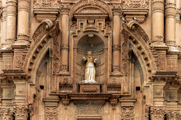 Damaged statue on the facade of the Temple of the Company of Jesus in Cusco, Peru