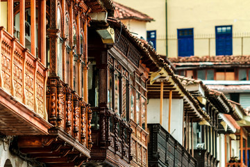 Wrought-wood balconies in front of the main square of Cusco (Peru) with hills in the background