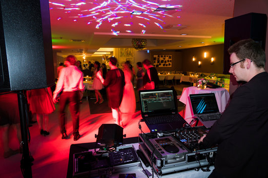 A mobile disc jockey turn on the music at a wedding celebration - wedding party dj