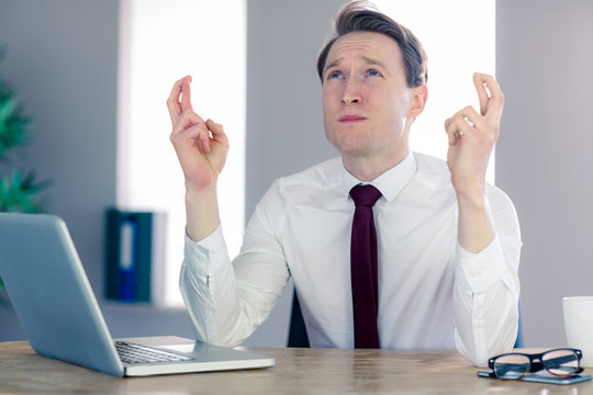 Wishing businessman crossing his fingers