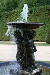 Three dancers bronze sculpture fountain in Versailles in the bright summer day
